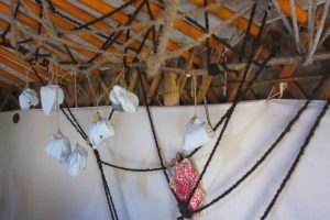 Das sind keinesfalls kleine Weihnachtsgeschenke die etwa da vom Dach der Jurte hängen, sondern ein Traumnetz mit Traumkugeln. Zu unserem vorweihnachtlichen Traumjurtenworkshop kommen wir aber eigentlich erst im nächsten Blog. Sie müssen sich also wohl noch etwas gedulden. Schubsen Sie nicht! Es kommt schon, Alles eben zu seiner Zeit.